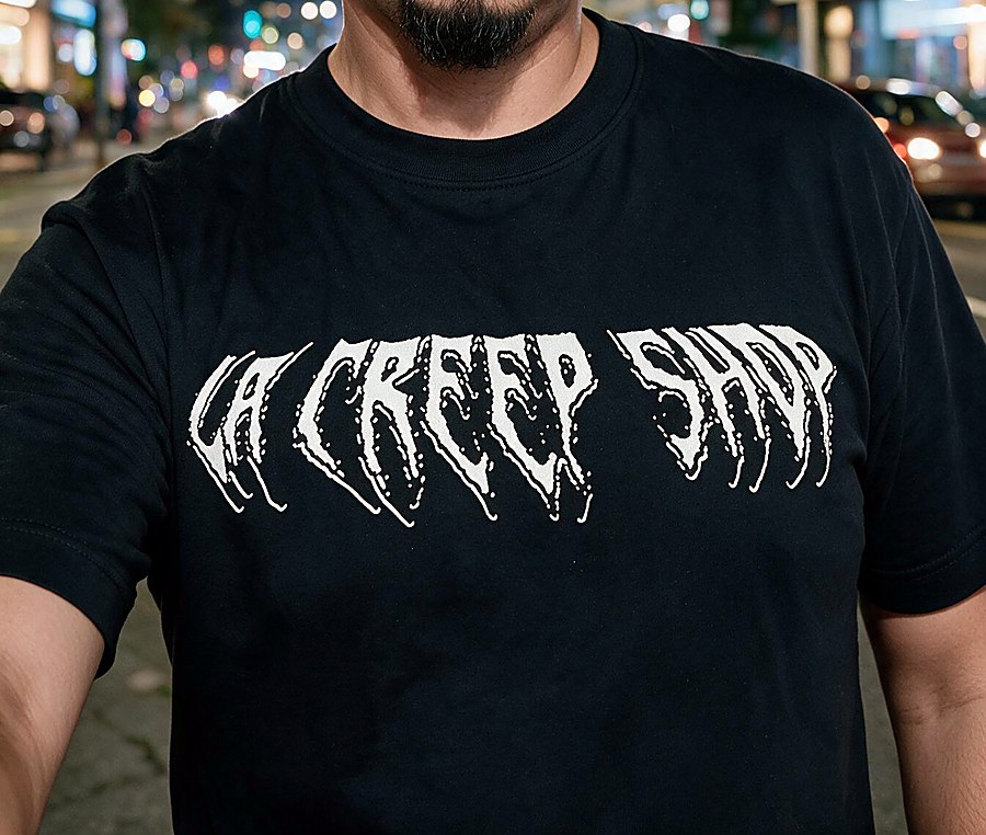 Person wearing a black tee with white horror-style drip lettering reading LA Creep Shop