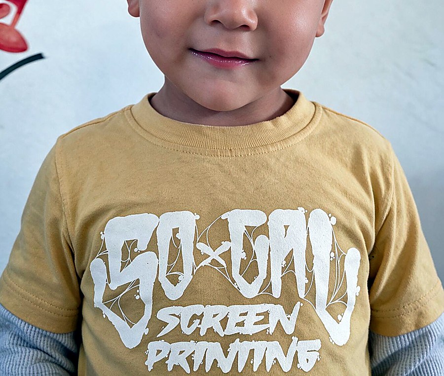 Child wearing a yellow tee printed with the SoCal Screen Printing graffiti logo