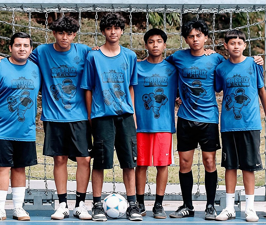 Youth soccer team standing in front of a goal wearing matching printed blue jerseys
